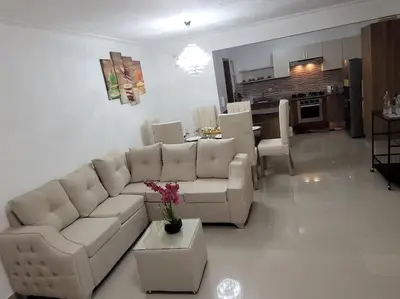 a living room with a white couch and a kitchen at El mejor alojamiento en Santiago in Santiago de los Caballeros