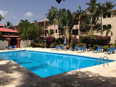 a swimming pool in front of a hotel at Cita del Sol City Apartments in Cabarete