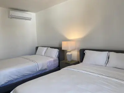 a bedroom with two beds and a lamp on a table at The Palm Bay Club Lodge in Nagua