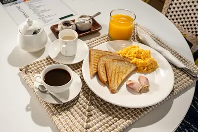 a breakfast of eggs toast and coffee on a table at The Palm Bay Club Lodge in Nagua