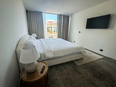 a bedroom with a bed and a table with a lamp at The Palm Bay Club Lodge in Nagua