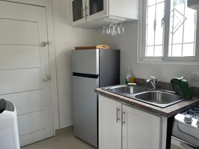 a kitchen with a white refrigerator and a sink at Cielo de cierro-Apartment with Jacuzzi, 2 minutes from the beach in La Romana
