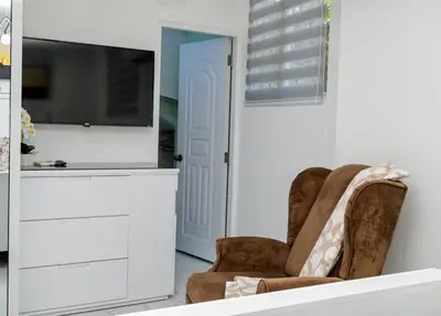 a living room with two chairs and a flat screen tv at Apartamento moderno de una habitación in San Pedro de Macorís