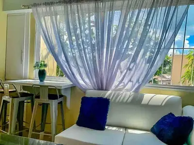 a living room with a white couch and a window at Suite in San Pedro De Macoris in San Pedro de Macorís