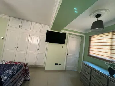 a bedroom with a bed and a flat screen tv at Suite in San Pedro De Macoris in San Pedro de Macorís