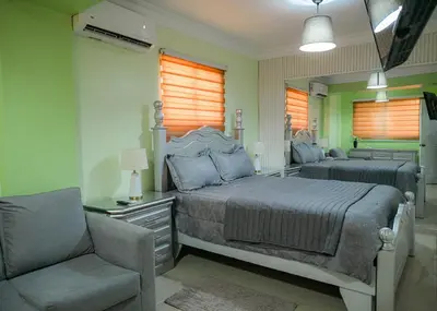 a bedroom with a bed and a chair and a mirror at Suite in San Pedro De Macoris in San Pedro de Macorís