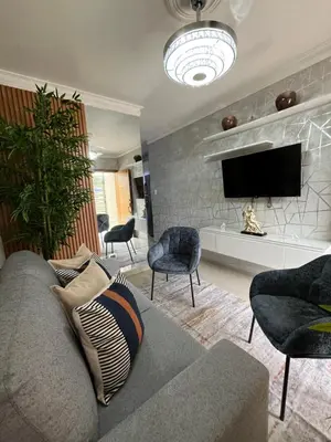 a living room with a couch and chairs and a tv at Apartamento de Lujo En San Pedro in San Pedro de Macorís