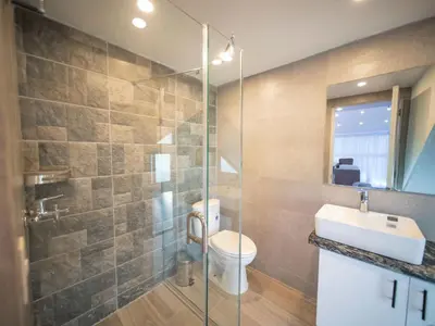 a bathroom with a shower and a toilet and a sink at 3BR Luxury Penthouse, 300m From Beach in Sosúa