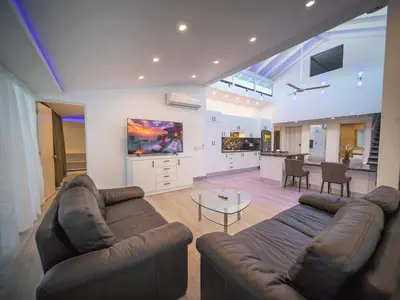 a living room with two couches and a kitchen at 3BR Luxury Penthouse, 300m From Beach in Sosúa
