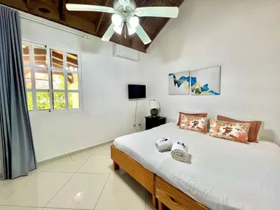a bedroom with a bed and a ceiling fan at Casati Pearl House, Big House With Private Pool in Bombita