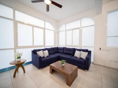 a living room with a blue couch and a table at Plaza Achim 6b, Modern Apt 250m From Sosua Beach in Sosúa