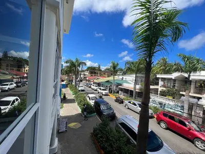 a view from a window of a street with a palm tree at Plaza Achim 6b, Modern Apt 250m From Sosua Beach in Sosúa