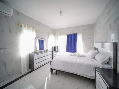 a white bedroom with a bed and a television at 8br Private Villa In Sosa - 2 Mins From Nightlife in Sosúa