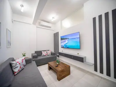 a living room with a couch and a tv on a wall at Cozy 1 Bedroom Apartment in Heart of Sosa in Sosúa