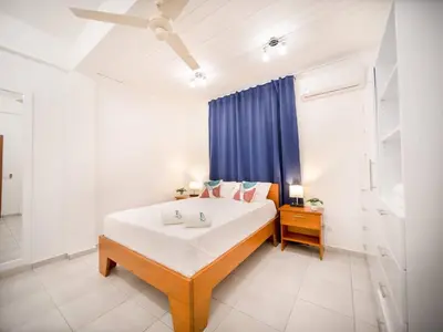 a bedroom with a bed and a blue curtain at Cozy 1 Bedroom Apartment in Heart of Sosa in Sosúa