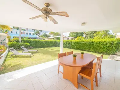 a table and chairs under an umbrella on a patio at Casati Family House, Great Pool Garden in Sosúa