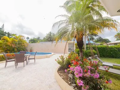 a patio with a table and chairs and flowers at Casati Family House, Great Pool Garden in Sosúa