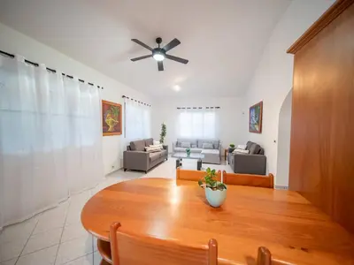 a living room with a table and a ceiling fan at Casati Family House, Great Pool Garden in Sosúa
