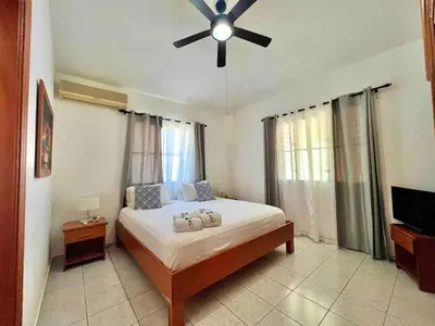 a bedroom with a bed with a ceiling fan at Casati Family House, Great Pool Garden in Sosúa