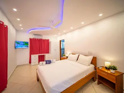 a bedroom with a large bed and a red curtain at 2BR Luxury Apartment in Heart Of Nightlife Area in Sosúa