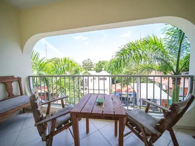 a balcony with a wooden table and two chairs at 2BR Luxury Apartment in Heart Of Nightlife Area in Sosúa