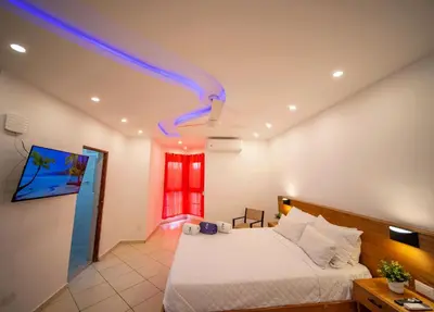 a bedroom with a white bed and a room with a blue ceiling at 2BR Luxury Apartment in Heart Of Nightlife Area in Sosúa