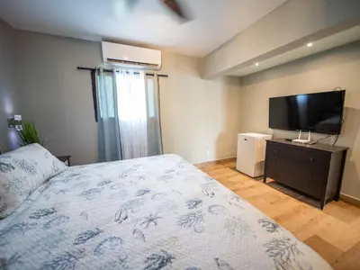a bedroom with a bed and a flat screen tv at 4br Penthouse With Rooftop Pool In Sosua Strip in Sosúa