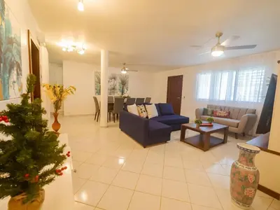 a living room with a blue couch and a table at 7br Massive Villa In Sosa - 2mins From Nightlife in Sosúa