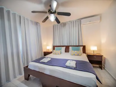 a bedroom with a bed with a ceiling fan at 7br Massive Villa In Sosa - 2mins From Nightlife in Sosúa