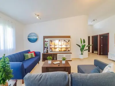 a living room with blue couches and a table at 7br Massive Villa In Sosa - 2mins From Nightlife in Sosúa