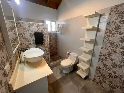 a bathroom with a toilet and a sink and shelves at Vittoria's House 402 in Bayahibe