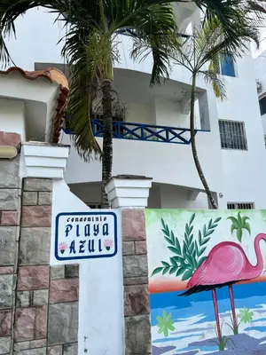 a sign in front of a building with a flamingo painted on it at Playa Azul House in Bayahibe