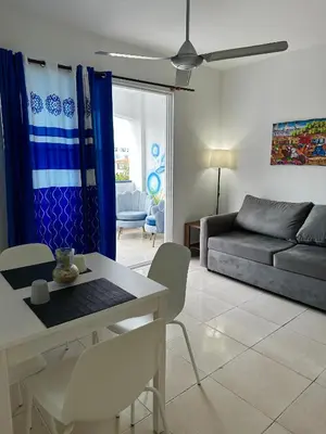 a living room with a couch and a table and chairs at Playa Azul House in Bayahibe