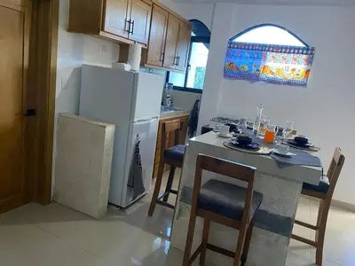 a kitchen with a white refrigerator and a table with chairs at Apartamento JGB 2 in Sosúa