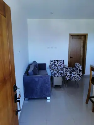 a living room with a blue couch and chairs at Apartamento JGB 2 in Sosúa