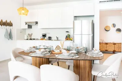 a kitchen with a dining room table with white chairs at Estrella Dominicus deluxe Apartment in La Laguna