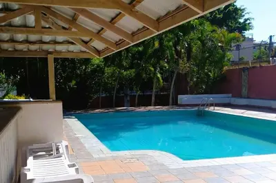 a swimming pool with a pergola and chairs next to it at Cozy & Spacious Apartament Boca Chica Beach in Boca Chica