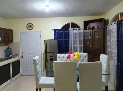 a dining room with a glass table and white chairs at Villa Privada con Piscina a Minutos del Aeropuerto de Santo Domingo in Boca Chica