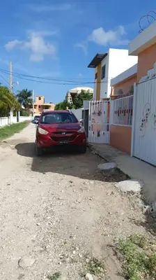 a red car parked on the side of a street at Villa Privada con Piscina a Minutos del Aeropuerto de Santo Domingo in Boca Chica