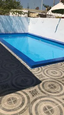 a swimming pool with blue water on a tiled floor at Villa Privada con Piscina a Minutos del Aeropuerto de Santo Domingo in Boca Chica