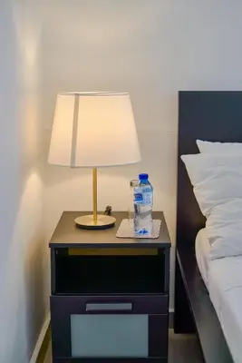 a table with a bottle of water and a lamp at Escape Studio Close to Agora Mall in Santo Domingo