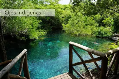 a bridge over a river with people swimming in the water at Caribbean Retreat at Cana Bay Golf Residence in Punta Cana
