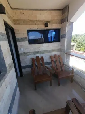 a room with two chairs and a tv on a wall at Apartamentos JGB in Sosúa Abajo