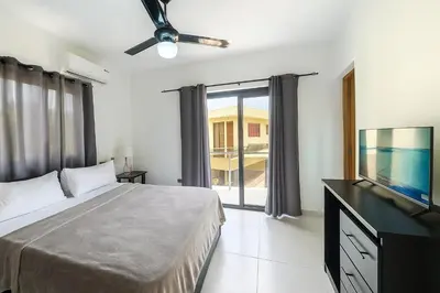 a bedroom with a bed and a flat screen tv at Modern 3 Bedroom Penthouse Apartment with Free Parking in San Felipe de Puerto Plata