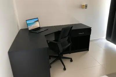 a black desk with a laptop and a chair at Modern 3 Bedroom Penthouse Apartment with Free Parking in San Felipe de Puerto Plata