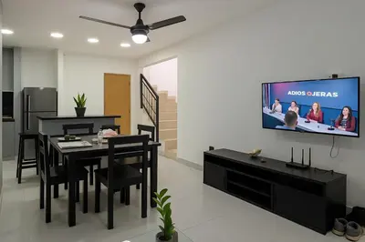 a dining room with a table and a tv on a wall at Modern 3 Bedroom Penthouse Apartment with Free Parking in San Felipe de Puerto Plata