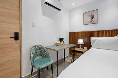a bedroom with a bed and a table and a chair at Hotel Vista Caribe Azúa in Azua de Compostela