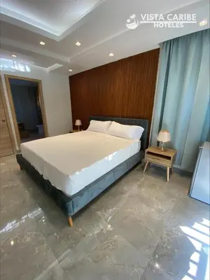 a bedroom with a large bed in a room at Hotel Vista Caribe Azúa in Azua de Compostela