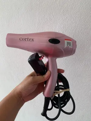 a person holding a pink hair dryer with a phone at Plataview Apartahotel apt 3A in Monte Plata