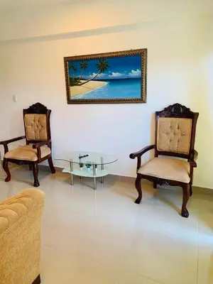 a living room with two chairs and a glass table at Plataview Apartahotel apt 3A in Monte Plata